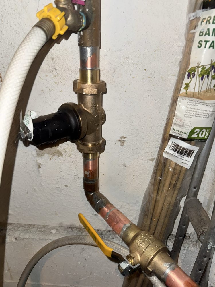Repaired copper backflow preventer and hose bib assembly on an exterior wall
