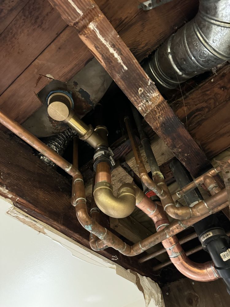 Plumber re-piping a clogged drain trap under a sink in Chicago, IL